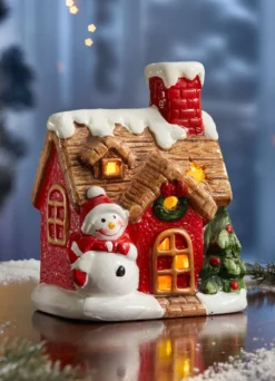 Beleuchtetes Haus mit Schneemann