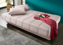Frei im Raum aufstellbares Schlafsofa mit Dekokissen und Bettkasten